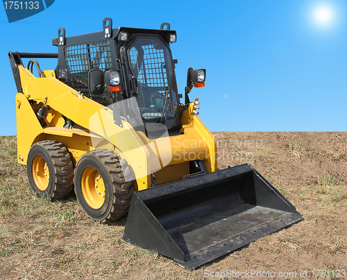 Image of The yellow truck with a scraper to lift cargo.