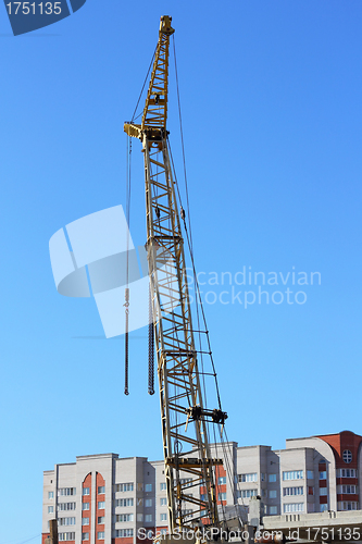 Image of yellow crane and blue sky on building site