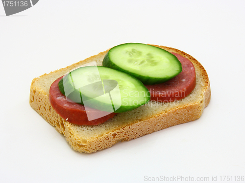 Image of sandwich with sausage and a cucumber 