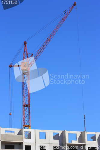 Image of red crane and blue sky on building site