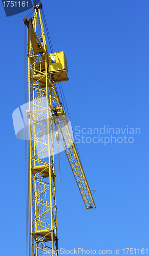 Image of yellow crane and blue sky on building site