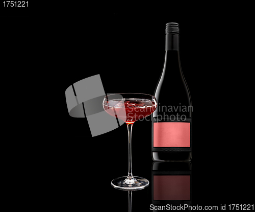 Image of a glass of red wine and a bottle