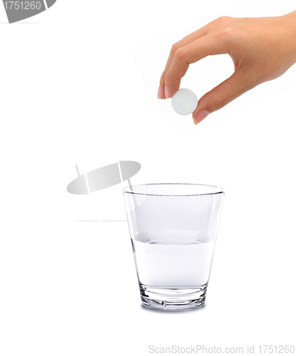 Image of Tablet of sedative in a hand above a glass with water