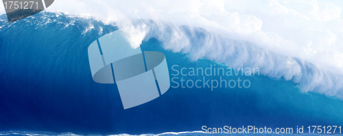 Image of Large Blue Surfing Wave Breaks in the Ocean