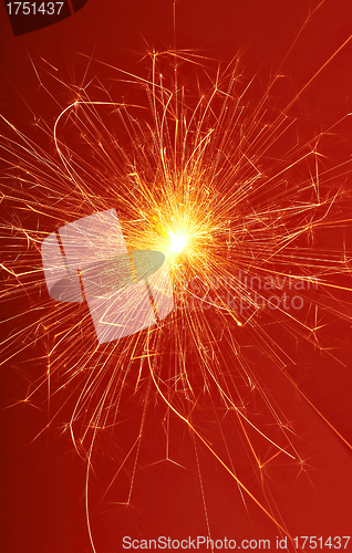 Image of fireworks sparkler on red background