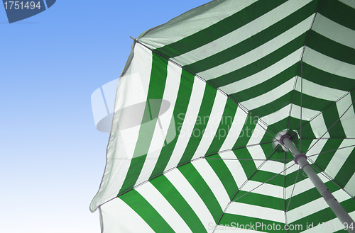 Image of Colorful beach umbrella against sunny blue sky