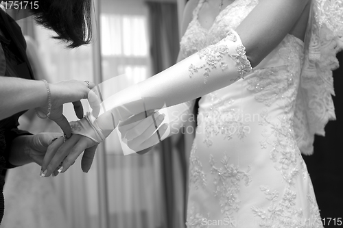 Image of Friend help the bride to wear a glove.