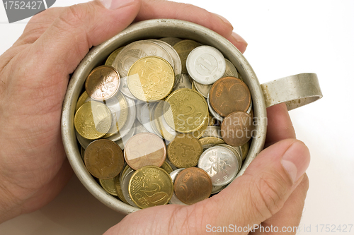 Image of Old aluminum mug and coins.