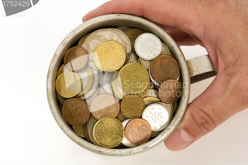 Image of Old aluminum mug and coins.