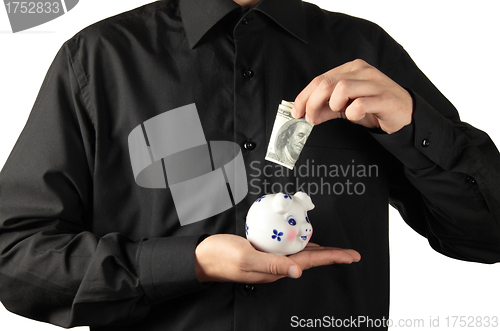 Image of money into piggy bank