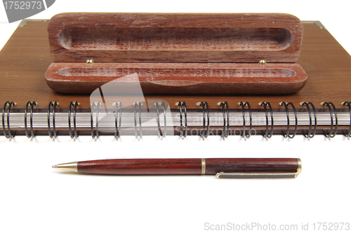 Image of pen in an opened wooden case on notebook