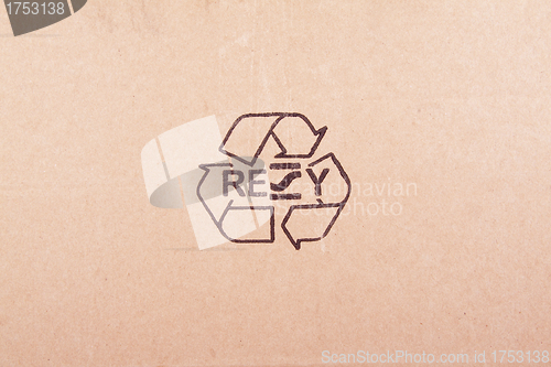 Image of torn out piece of cardboard with recycle symbol