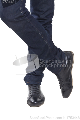 Image of Man's feet in blue trousers and black shoes