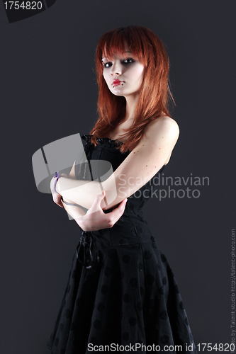 Image of girl with red hair poses on black background