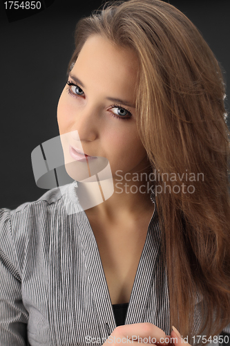 Image of beautiful brunette pulls hair , on gray background