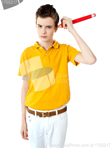 Image of Boy cleaning his ear with big pencil