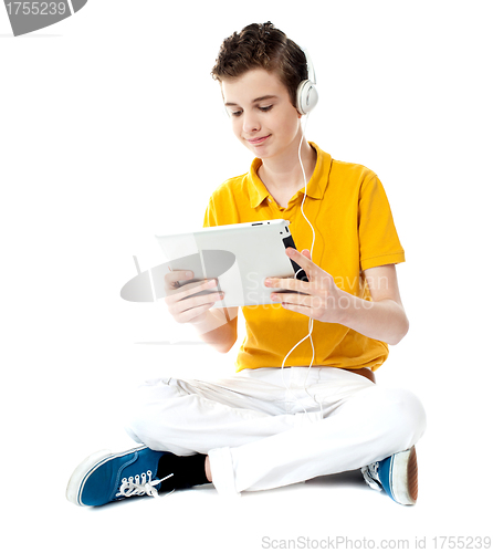 Image of Seated boy watching video on tablet