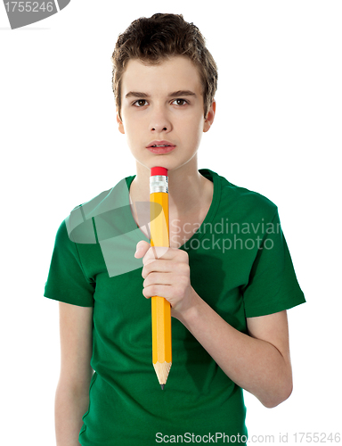 Image of School boy thinking while holding pencil