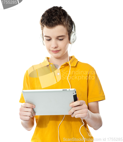 Image of Boy listening to music on tablet pc