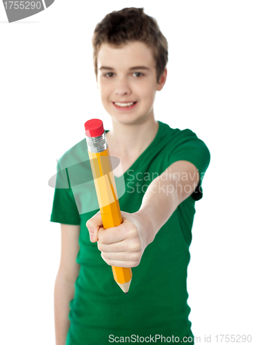 Image of Young boy showing big yellow pencil