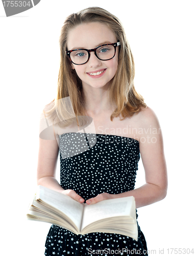 Image of Cute little girl standing with an open book