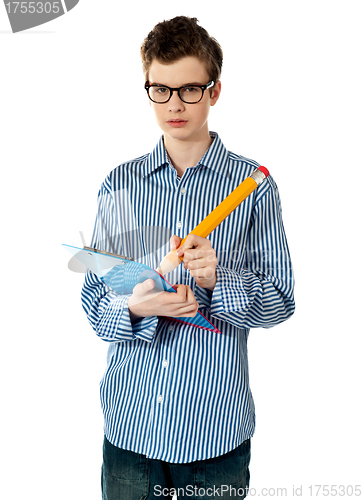 Image of A boy writing on spiral notebook