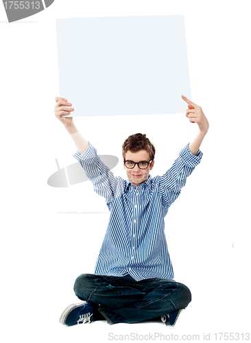 Image of Boy pointing towards white blank billboard