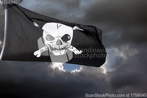 Image of Jolly Roger (pirate flag) against storm clouds