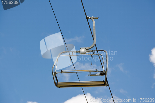 Image of An empty ski chair lift with blue sky