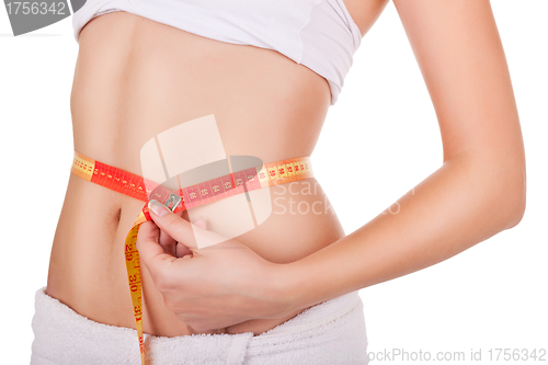 Image of young woman's waist wrapped in a tape measure