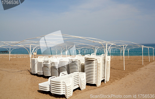 Image of Empty beach with sun lounger