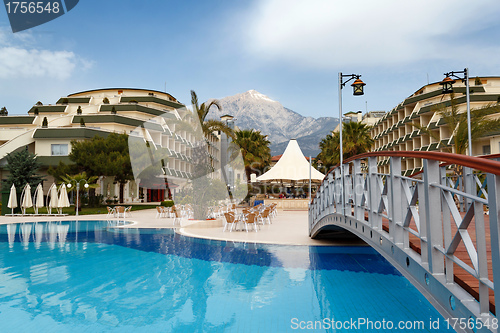 Image of luxury hotels exterior with pool and small bridge