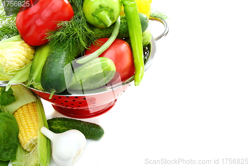 Image of Summer vegetables and greens in a colander.