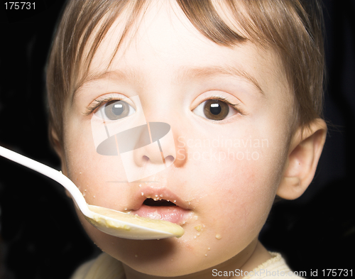 Image of baby being fed with spoon by his mother