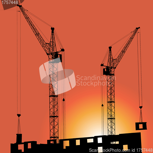Image of Silhouettes of crane on building against 