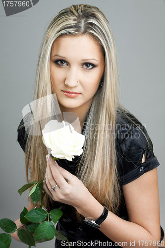 Image of beautiful young blond woman with a flower in her hands
