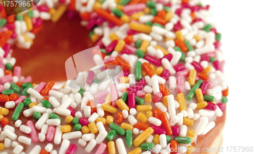 Image of Pink Iced Doughnut covered in sprinkles isolated