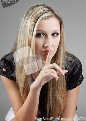 Image of very attractive female holds finger on her lips