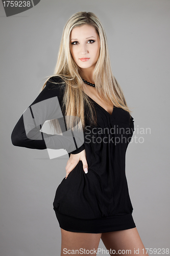 Image of Young blonde woman posing in stylish dress