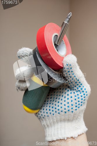 Image of Hand holding screwdriver and electrical tape
