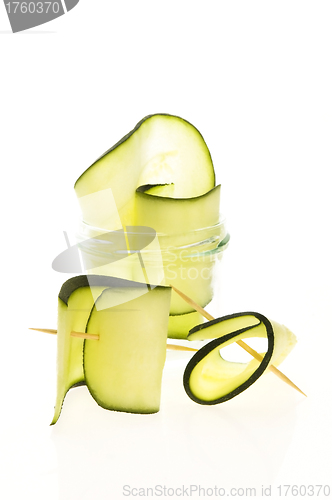 Image of Pile of sliced zucchini pieces arranged on white background