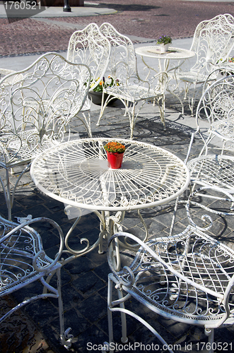 Image of Decorative white tables and chairs outside cafe 