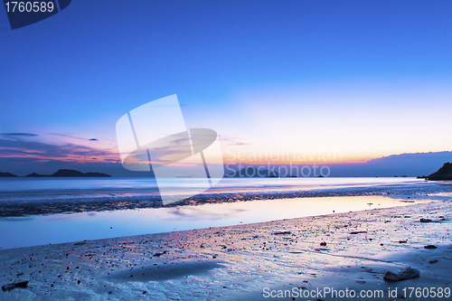 Image of Sunset coast with reflection of clouds