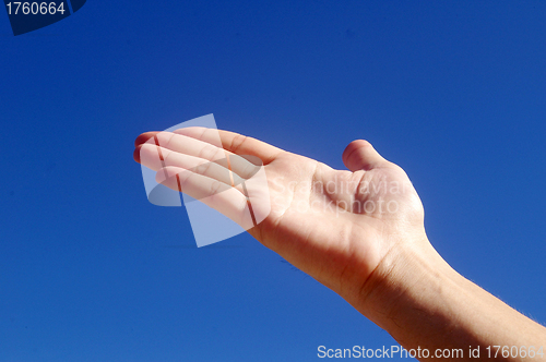 Image of Giving hand under blue sky