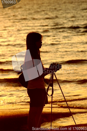 Image of Female photographer under sunset