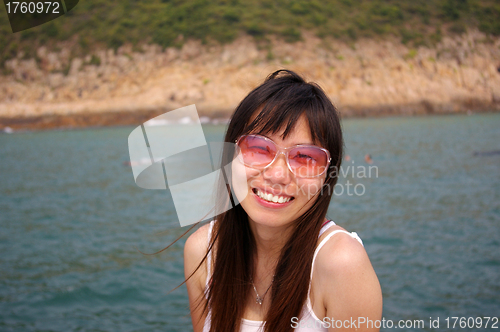 Image of Asian woman smiling with sunglasses in summer