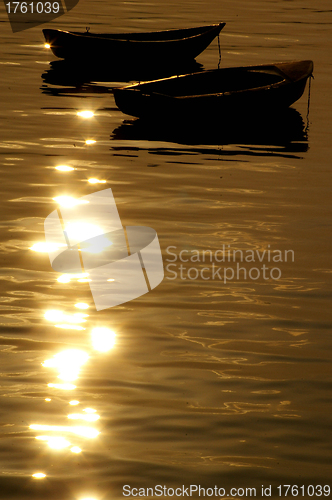 Image of Boats over the ocean at sunset