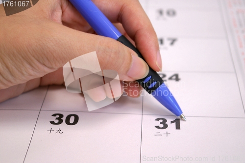 Image of Human hand writing calendar