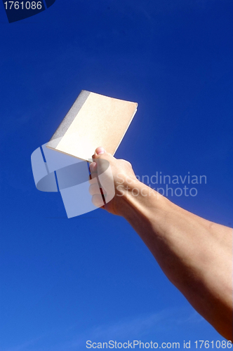 Image of Holding notebook under blue sky