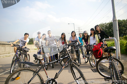 Image of Asian friends riding bicycle